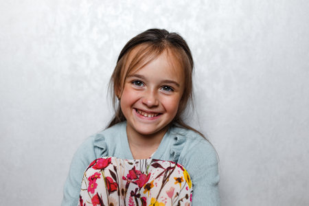 Portrait of a happy smiling girl, on a light backgroundの写真素材