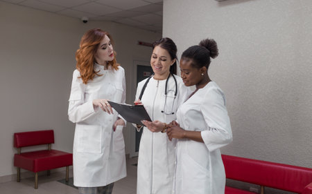 A team of successful women healthcare doctors discuss medical issues in the hospital corridorの写真素材
