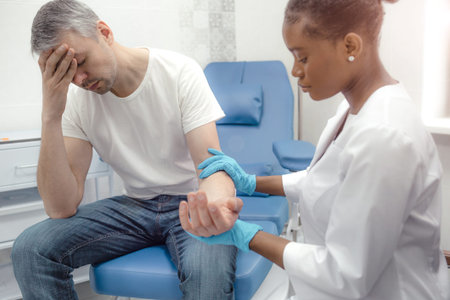 a patient suffering from a severe headache at an appointment with an African-American female doctor.の写真素材