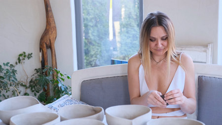 caucasian girl sculpts pottery with her hands.の写真素材