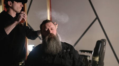 The barber splashes water on the client's hair. hair cut in the salonの写真素材