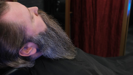 a large portrait of a bearded man sitting in a barber chair.の写真素材