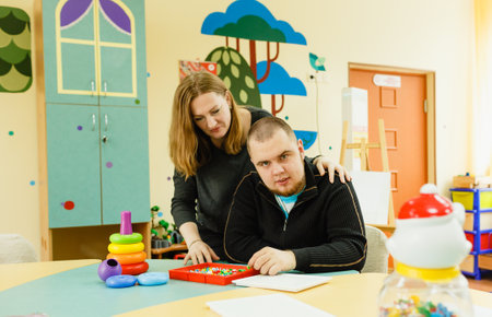 a psychologist is engaged with an adult autistic man in the office.の写真素材