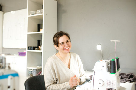 a tailor girl sews clothes in an atelier.の写真素材