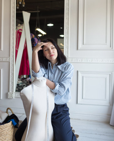 a designer girl creates clothes in an atelier, measures by a centimeter.の写真素材