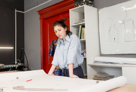 The designer-seamstress makes precise measurements for sewing clothes. The concept of creating clothes.の写真素材