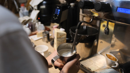 The process of making cappuccino. I work as a barista in a coffee shop. Whipping milk in a milk cooker. steamer. coffee machine.の写真素材