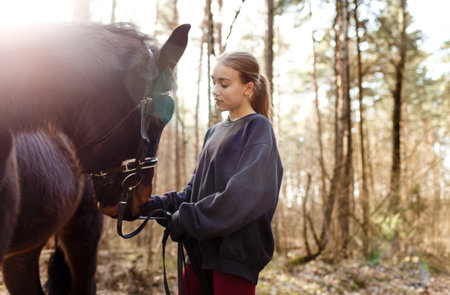 a young girl jockey trains to ride a horse.の写真素材