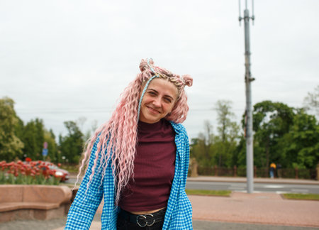 Attractive girl in headphones with pink hair and a blue shirt.の写真素材