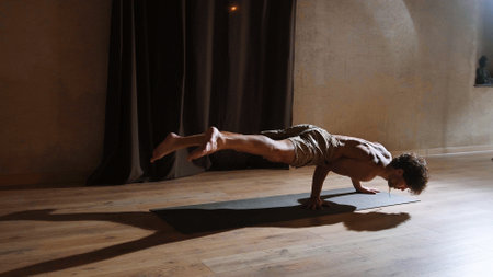 A young and athletic man does yoga and performs complex asanasの写真素材