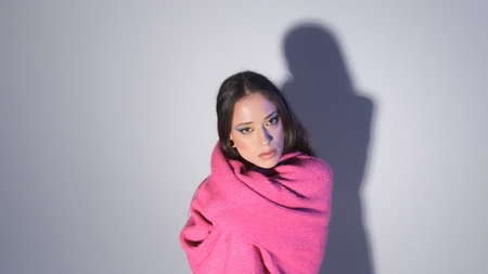 a girl in a red sweater poses on a light background.の写真素材