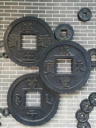 Copper coin sculpture at wallの写真素材