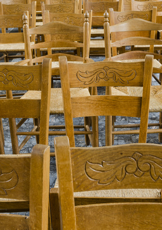 Several wooden, brown chairs with a leaf motive in the church of Marken, The Netherlands.の写真素材
