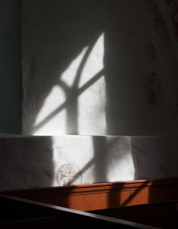 Light trough a church window on a white wall, church of Oostrum in the province of Groningen.のeditorial素材