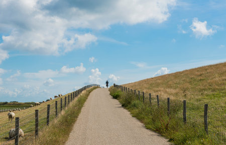 Cyclist on a dike on the isle of Texel near Oudeschild.