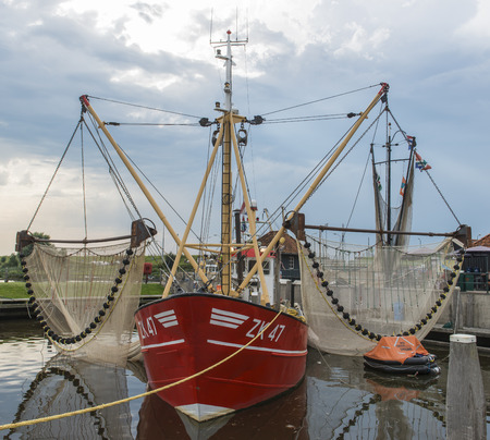 red fishing ship with two great nets in de port of Zoutkamp.のeditorial素材