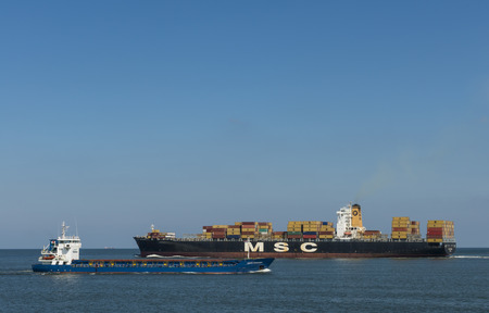 MSC Container ship and smaller ship for the port of Rotterdam near the Maasvlakte.のeditorial素材