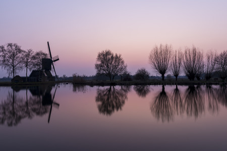 Mill at Woerdens Verlaat after sunset near the Kromme Mijdrecht and with refelection in the water.の写真素材