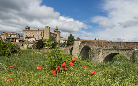 Roman Bridge, people, river, houses and Church of Monastero Bormida in Piedmont, Italyの写真素材