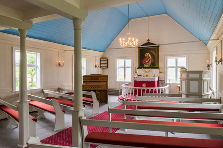 Nordurland Eystra, Iceland - July 2, 2016: interior of the church with red benches and white wooden interior in Iceland.のeditorial素材