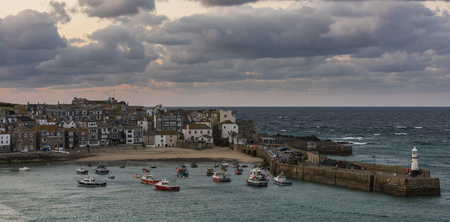 Saint Ives, England - April 29, 2017: Evening in the harbor, city and church with beach of Saint Ives in Cornwall, England.のeditorial素材