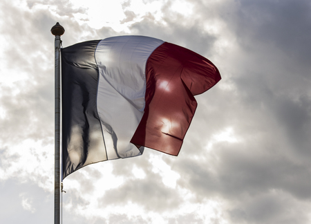 French Flag against the sun on a summers day with dark clouds.の写真素材