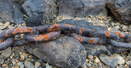 Link of a rusty and strong chain on rocks.の写真素材