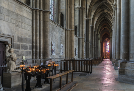 Reims, France - June 12, 2017: interior of the cathedral of Reims with many wooden chairs, high pillars and candles, France.のeditorial素材