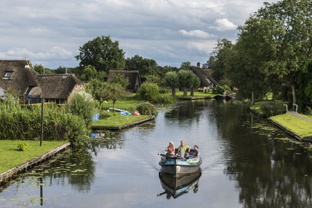 Giethoorn, The Netherlands - July 30, 2016:  Canal at Jonen with motor boat and tourists near  the small, picturesque town of Giethoorn, Overijssel, Netherlands.のeditorial素材