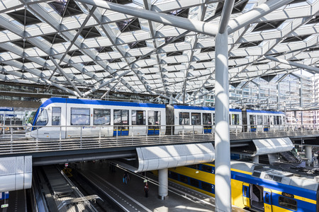 The Hague, The Netherlands - August 6, 2017: Central Train Station The Hague with construction, train, HTM tram, platforms and glass windows.のeditorial素材