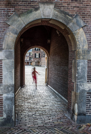 Child running through the port of the Binnenhof at the parliament buildings in The Hague, in the Netherlands.の写真素材