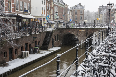Utrecht, Netherlands - December 11, 2017:  canals with trees, shops and a bridge in Utrecht in a winter snow storm, Netherlands.のeditorial素材