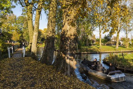 Giethoorn, The Netherlands - October 31, 2016:  Electric boat in autumn in the canals of the small, picturesque town of Giethoorn, Overijssel, Netherlands.のeditorial素材