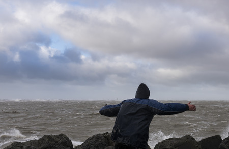 IJmuiden, The Netherlands - January 18, 2018: Man in storm at the North Sea at the Zuidpier at IJmuiden in Noord-Holland.のeditorial素材