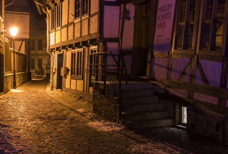 Wernigerode, Germany - February 6, 2018: Center of Wernigerode at the colorful  museum 'Schiefes Haus' with people waiting and listening to the guide at night in winter time.のeditorial素材