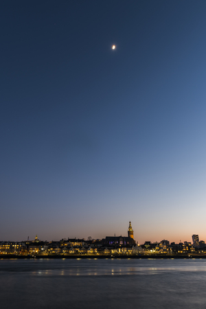 Nijmegen, The Netherlands - February 22, 2018: Nijmgen at night at the river Waal with the Stevenskerk, church, and moon in the province of Gelderland.のeditorial素材