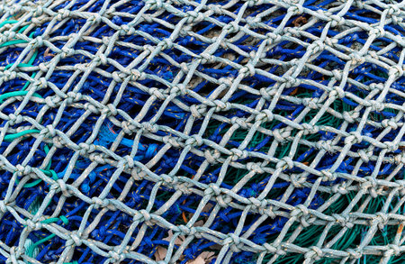 Blue and Green Fishing Net with ropes on a pile in Lymington, England.