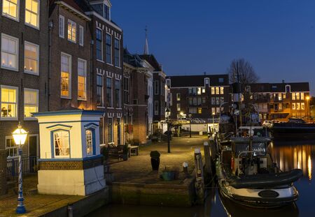 Maassluis, The Netherlands - February 26, 2019: the harbor of Maassluis with old boats, tugs and monumental houses at night.のeditorial素材
