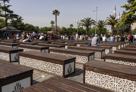 Instanbul, Turkey - April 29, 2019: People on the square and park in the centre of Instandbul with benches, minaret and palm trees.のeditorial素材