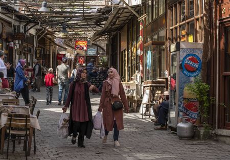 Safranbolu, Turkey - May 1, 2019:  Touristic village with tourists shopping at one of the main streets with restaurants and cafes and with turkish flags.のeditorial素材