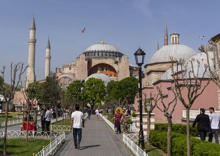 Instanbul, Turkey - April 29, 2019: People on the square and park in the centre of Istandbul with benches, minaret and palm trees.のeditorial素材