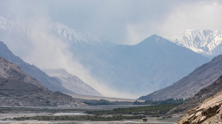 Panj River with trees and sand banks in the Wakhan Corridor on the border of Tajikistan and...