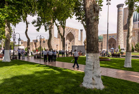 Samarqand, Uzbekistan - June 9, 2019: Square with people, trees and peopla at the madrasah in the centre of Samarqand in Uzbekistan.のeditorial素材