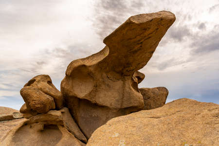Rock formations in Bektau Ata in Kazakhstan with sun and clouds during sunset.の写真素材