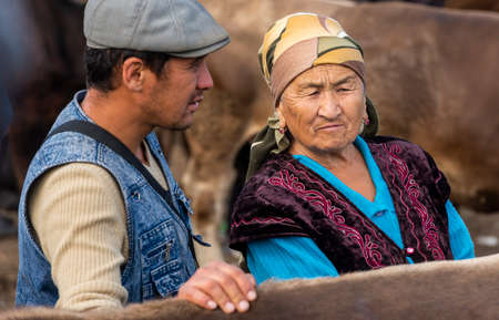Karakol, Kyrgyzstan - July 14, 2019: Man and Woman at livestock market in the city of Karakol in Kyrgyzstan.のeditorial素材