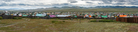 Bulgan, Mongolia - August 18, 2019: Panorama of the city of Bulgan with many wooden houses with colored roofs of the houses and a green field in summer.のeditorial素材