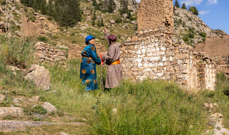 Zuunmod, Mongolia - August 25, 2019: Man and woman in traditional clothes offering rice near the monastery Manzushir in Mongolia.のeditorial素材