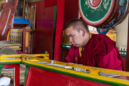 Bulgan, Mongolia - August 18, 2019: Yong monk in buddhist monastery of Dashchoinkhorlon Khiid with older monk in red habit.のeditorial素材