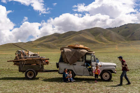 Baruuntunuun, Mongolia - August 8, 2019: Nomadic life on the steppe of Mongolia with moving family with two loaded cars and horse. on the steppe of Mongolia with moving family with loaded car.のeditorial素材