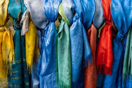Blue, yellow and red Khadags at a holy place in Mongolia.の写真素材